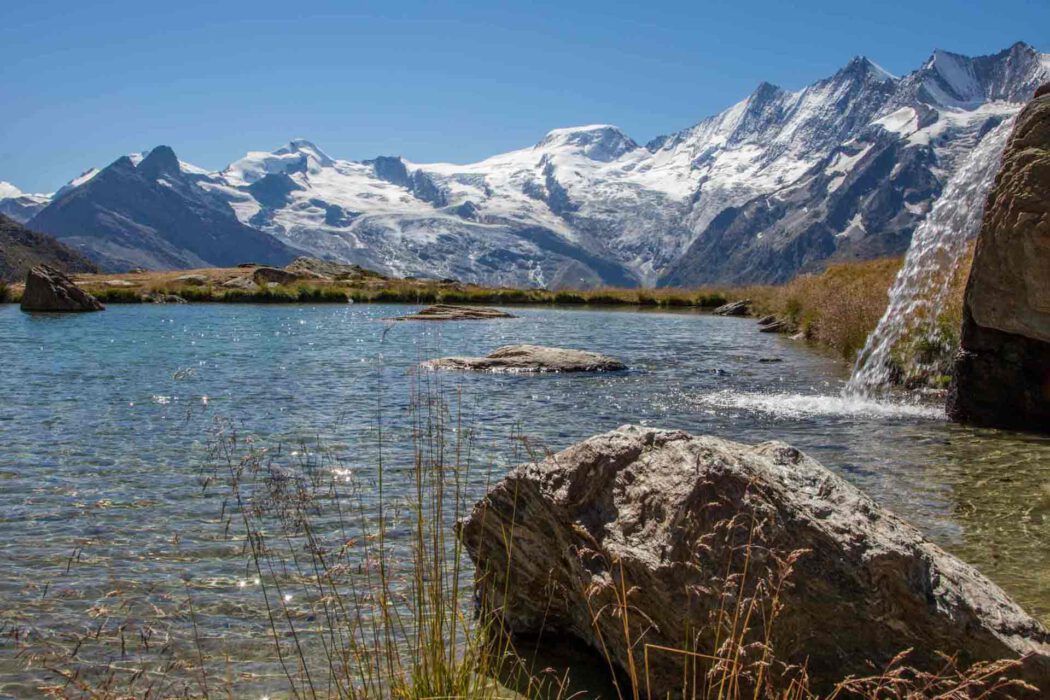 Kreuzbodensee mit Mischabelhörnern und Wasserfall in den Schweizer Alpen