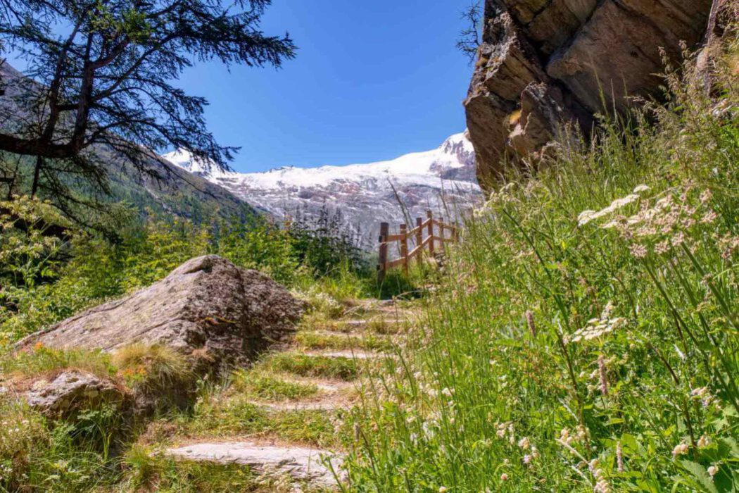 Wanderweg in den Alpen mit Schneebedeckten Bergen. Der Kapellenweg in Saas-Fee