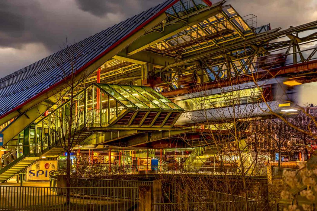 Schwebebahnstation Kluse in Wuppertal bei Nacht mit fahrendem Zug.
